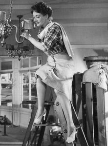 Mildred wears a mixture of masculine and feminine clothing while getting her restaurant ready. © 1945 – Warner Bros. All Rights Reserved.
